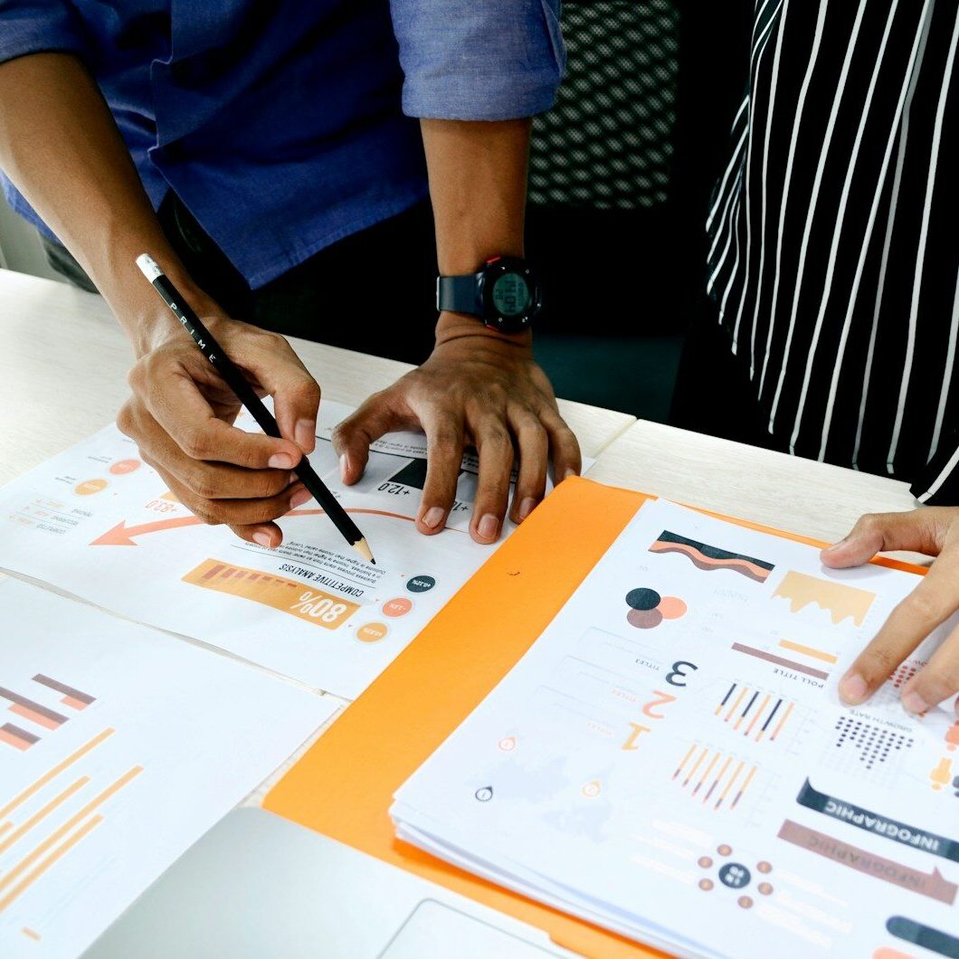 person in blue shirt writing on white paper